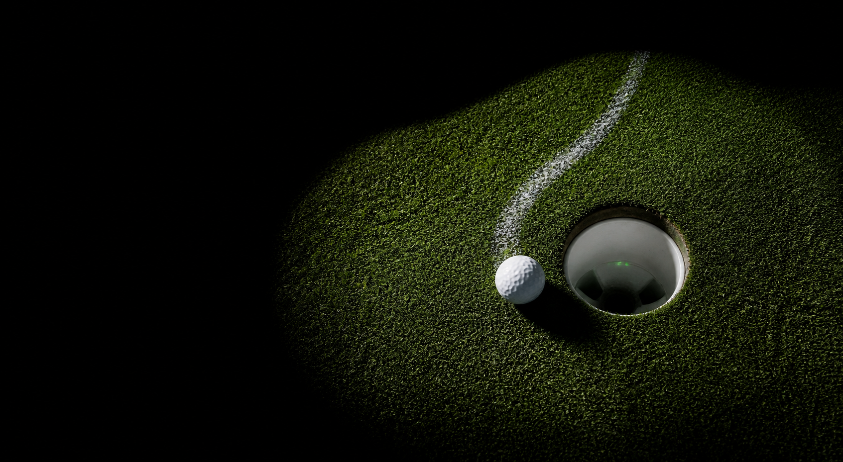 Balle de golf près d’un trou éclairé sur fond noir